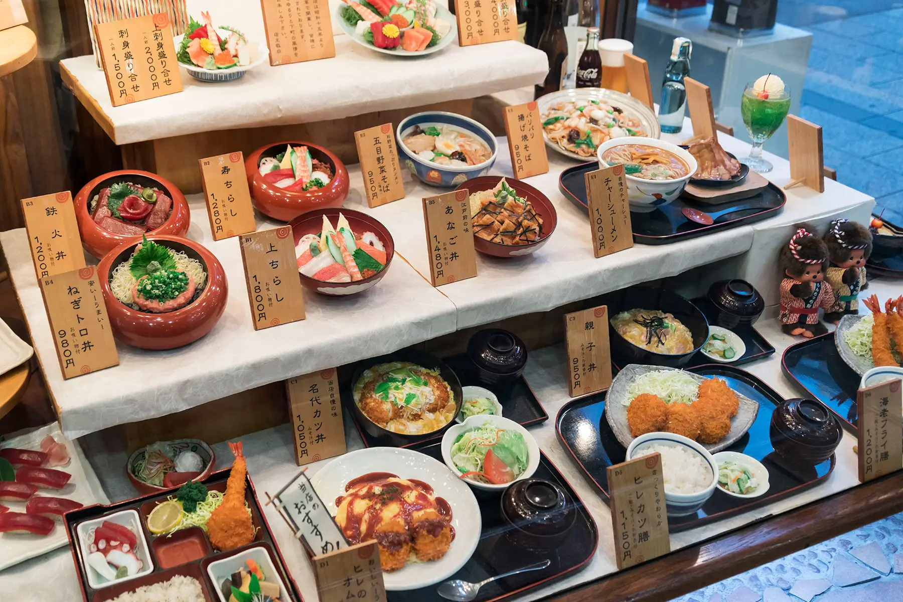 A chef of a Japanese style pub is cooking Japanese food in the kitchen of his shop, framed through the window.